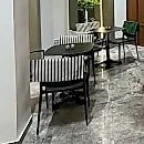 Bistro seating beside a planted corner of the members' lounge.