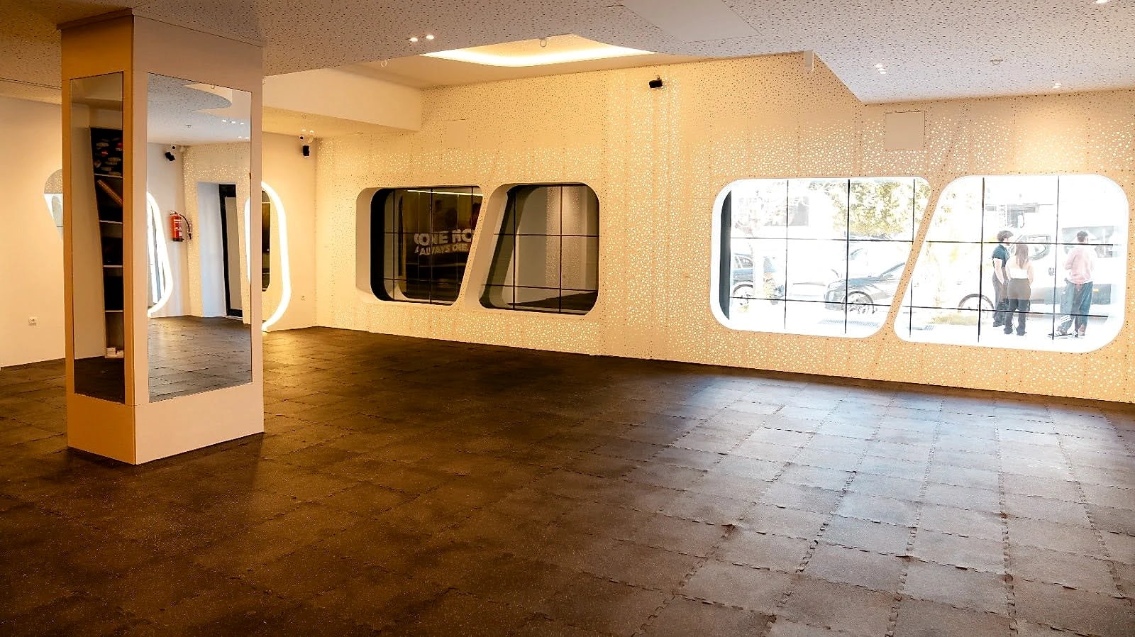 The studio at Naouar Prestige Gym — an open floor with curved glazing and warm cove lighting.